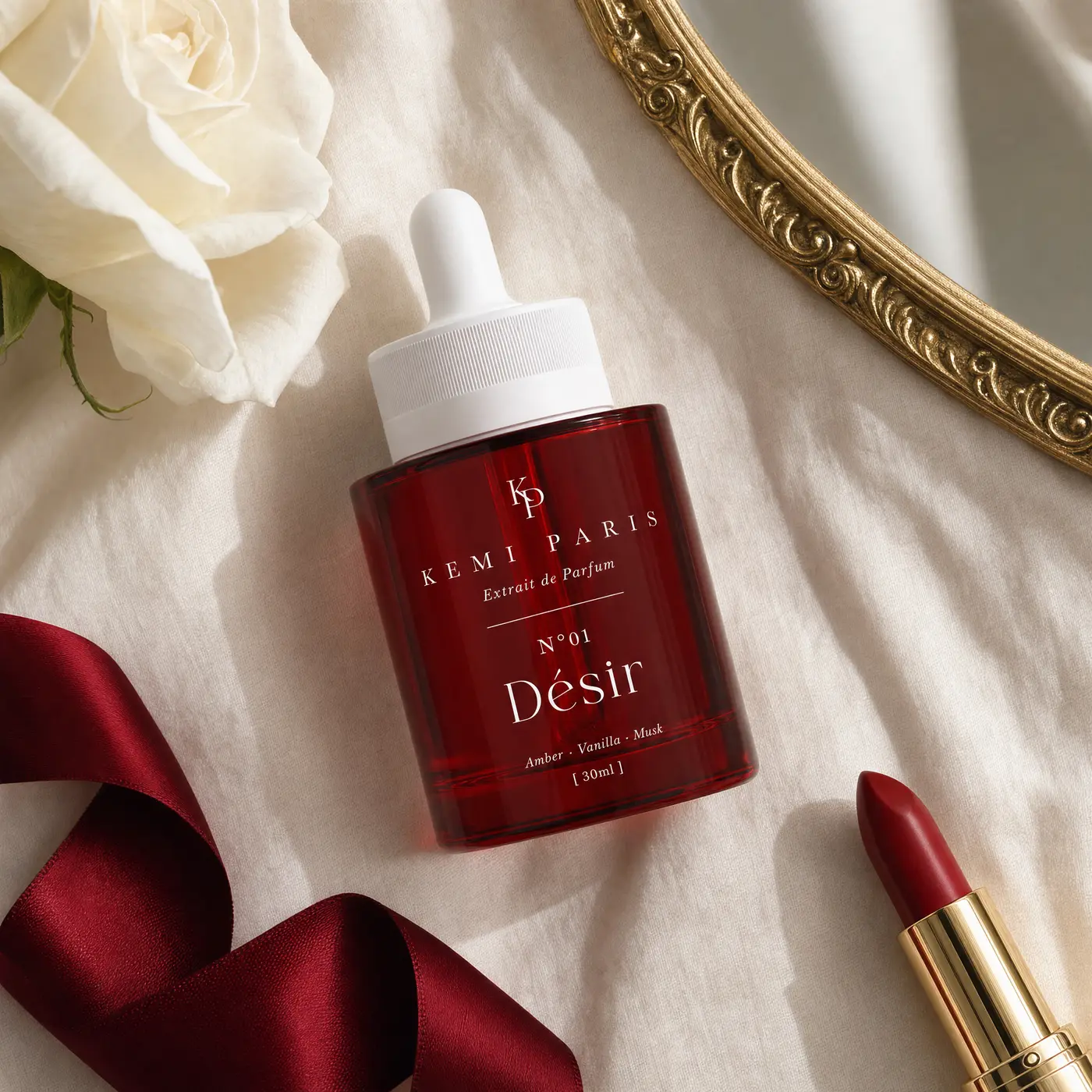 A gift edit: the red cylinder extrait, a white rose and ribbon on cream silk