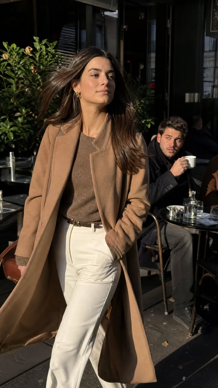 A stranger at a cafe turning his head as a woman walks past